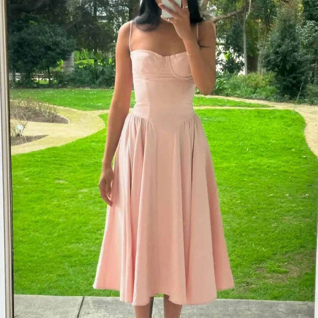 Woman wearing a bustier A-line midi dress with spaghetti straps.