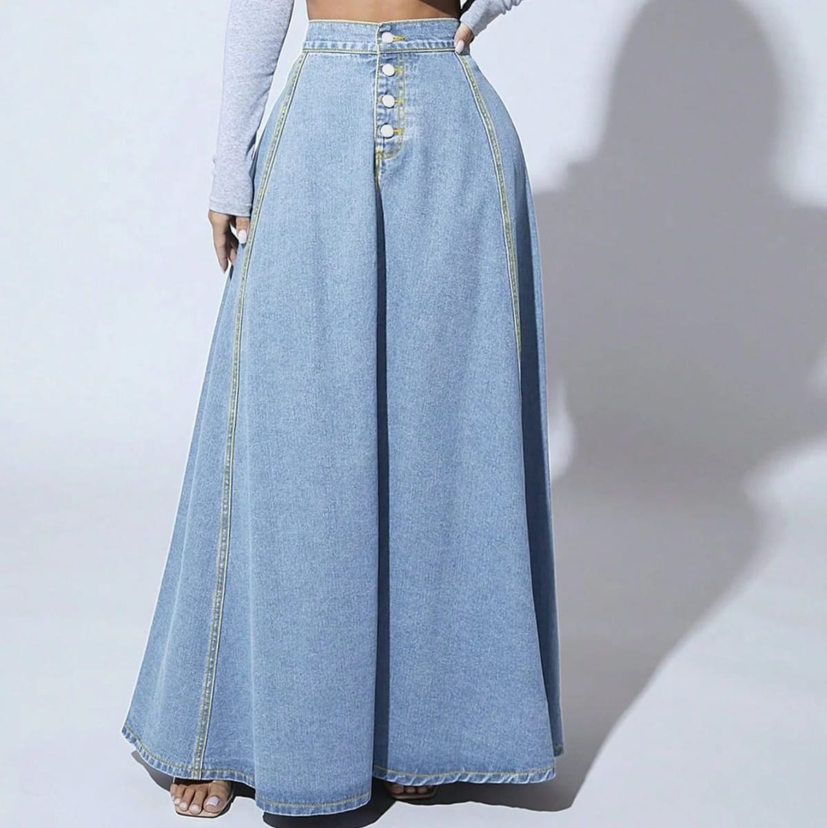 Model wearing a high-waisted denim maxi skirt with button front.