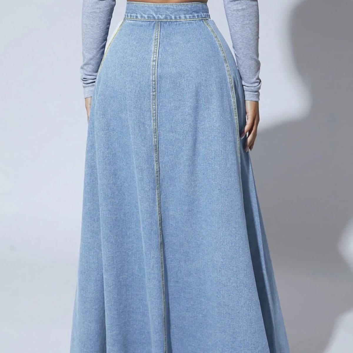 Model wearing a high-waisted denim maxi skirt with button front.