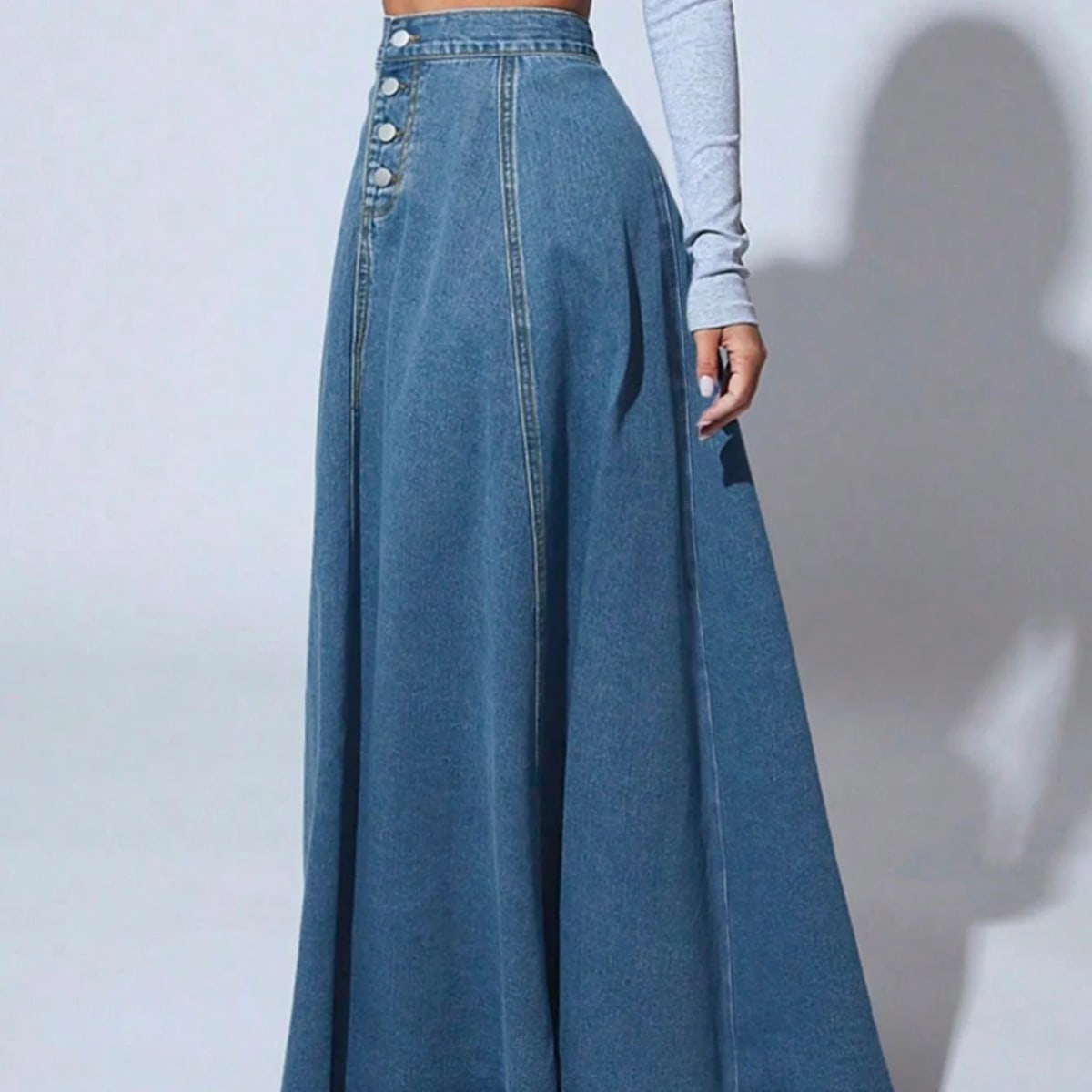 Model wearing a high-waisted denim maxi skirt with button front.