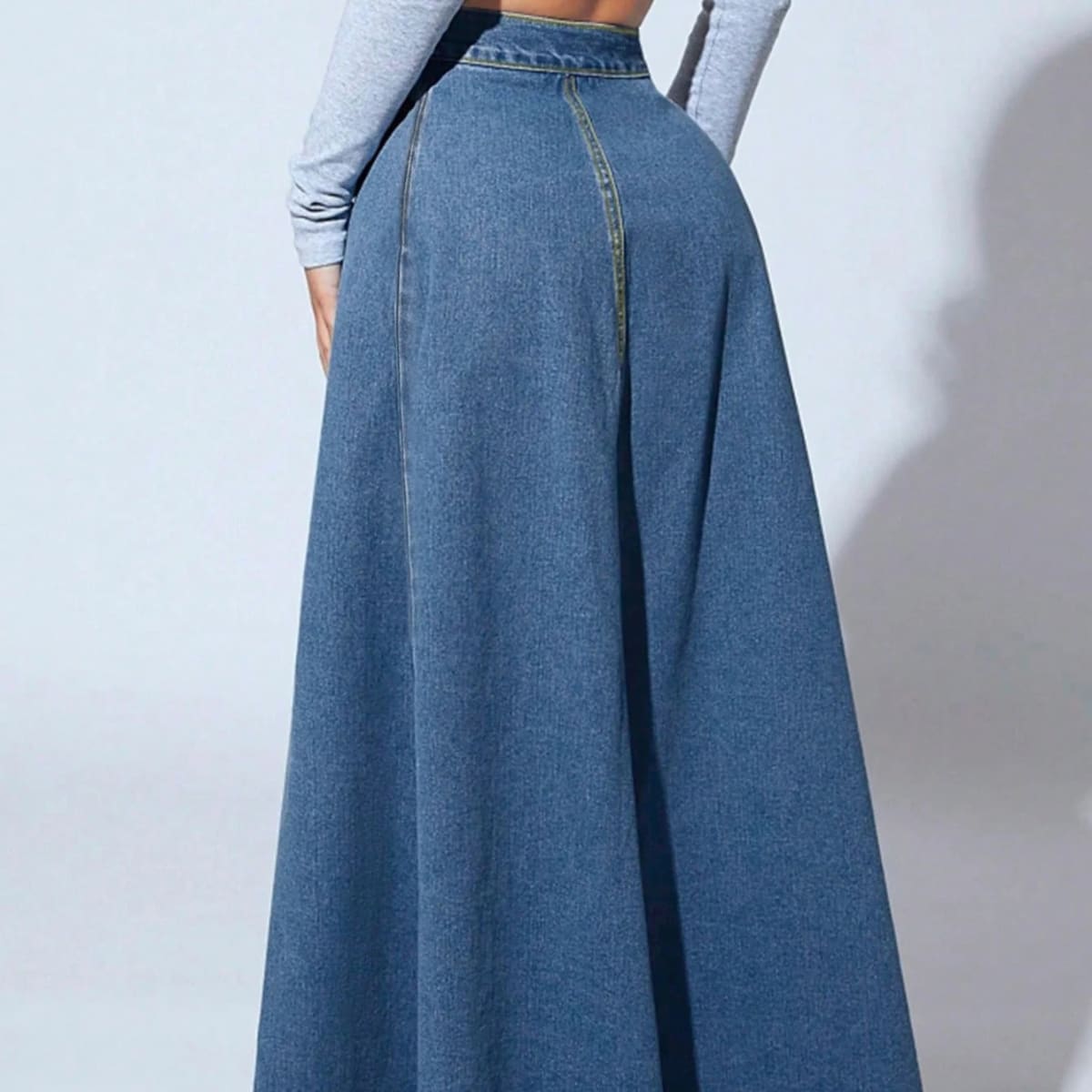 Model wearing a high-waisted denim maxi skirt with button front.
