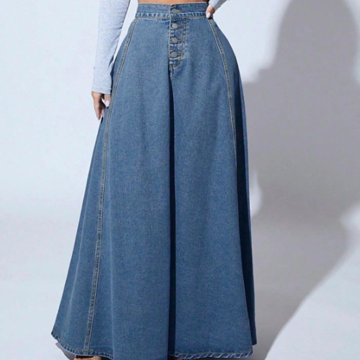 Model wearing a high-waisted denim maxi skirt with button front.
