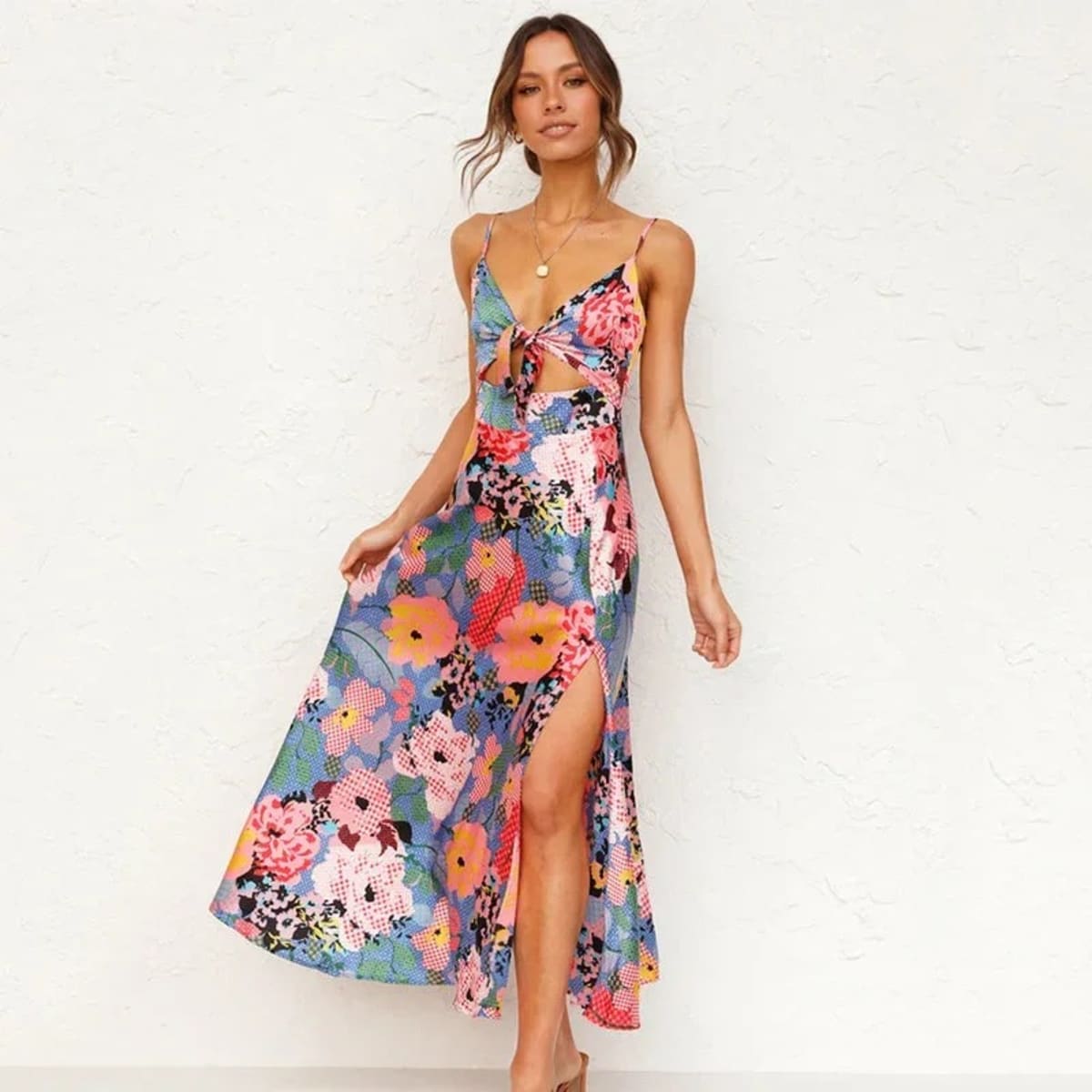 Woman in floral cutout midi dress with spaghetti straps.