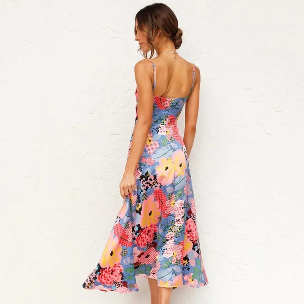 Woman in floral cutout midi dress with spaghetti straps.