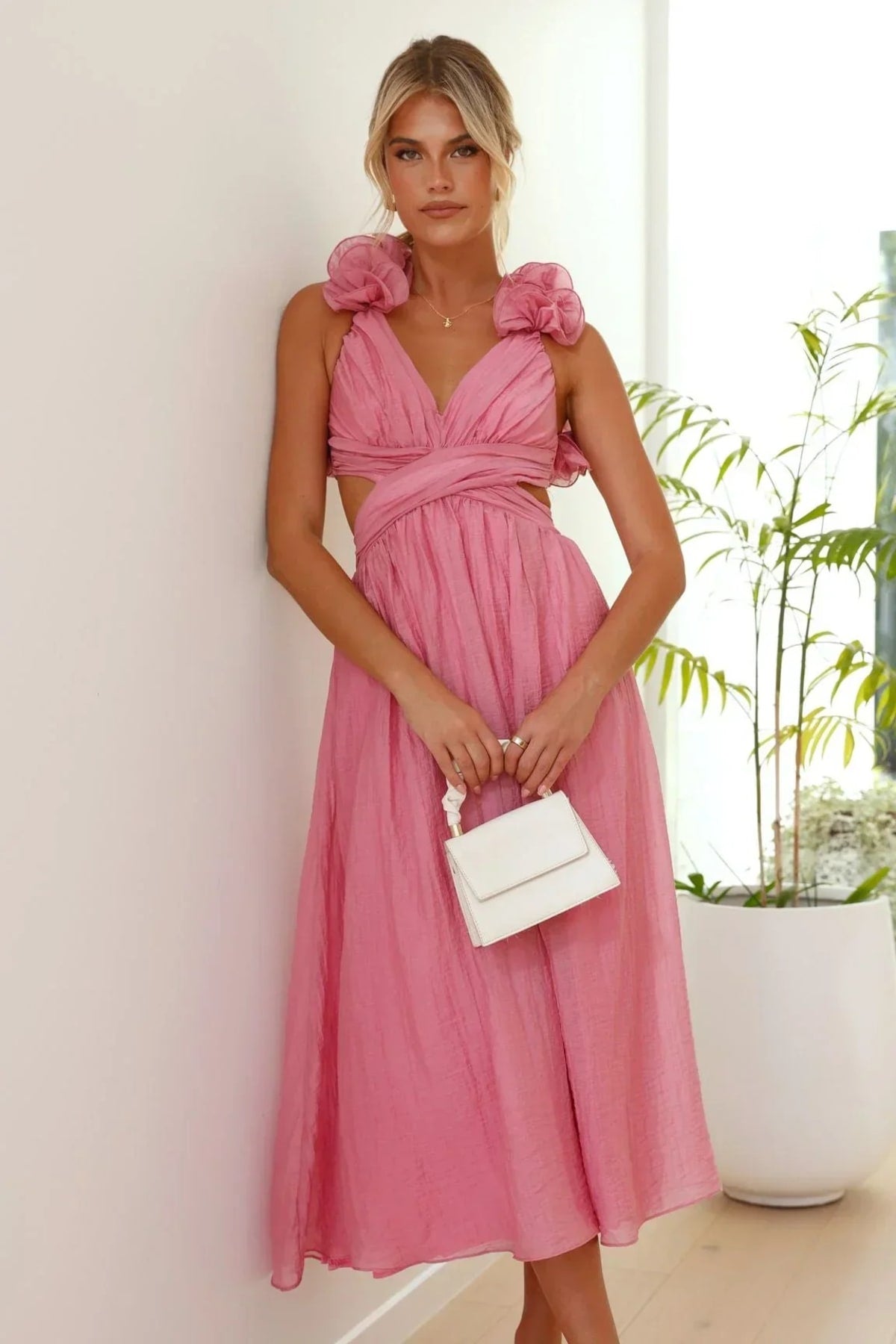 Woman wearing a midi dress with V-neck and floral shoulders.