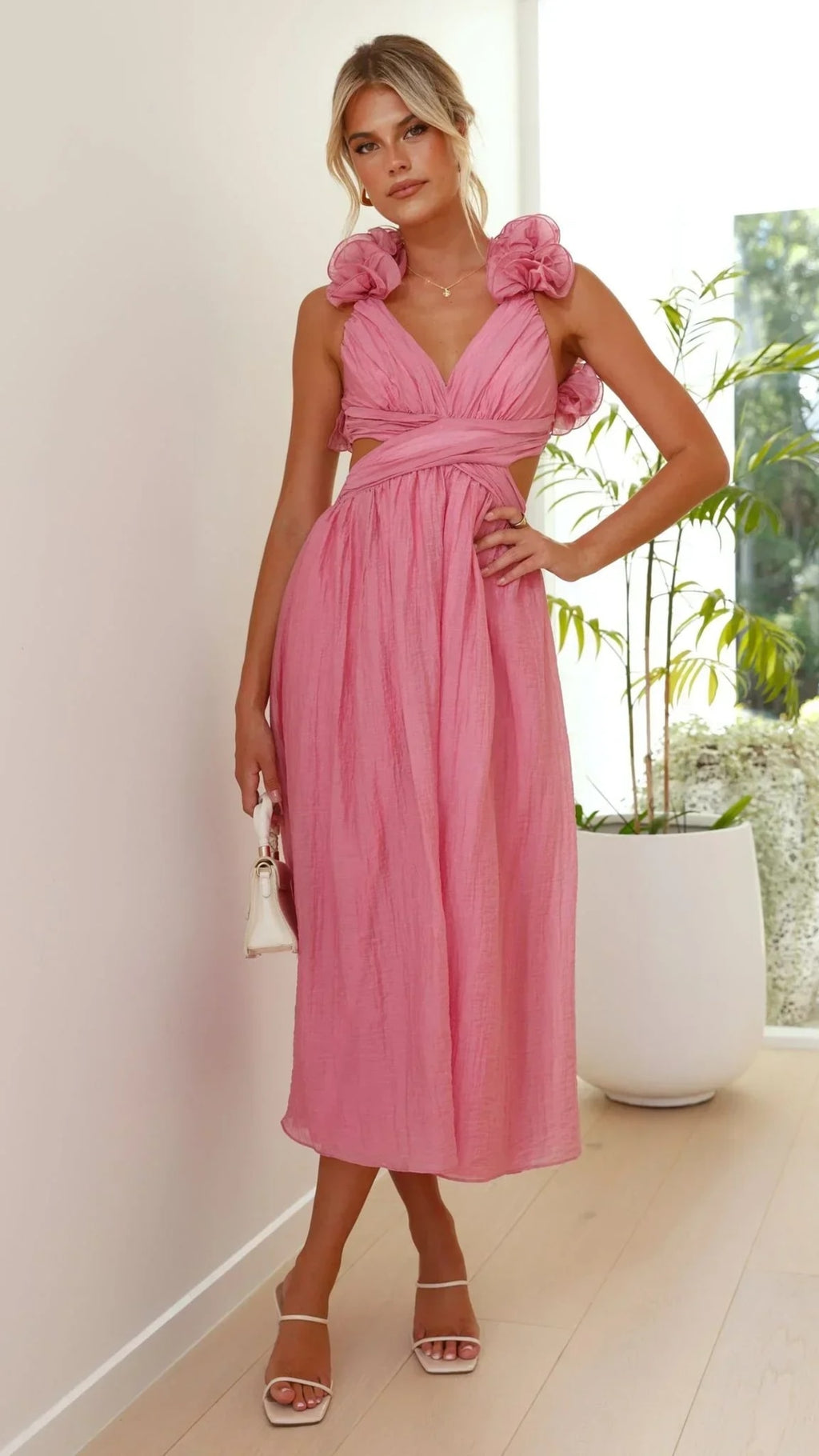 Woman wearing a midi dress with V-neck and floral shoulders.