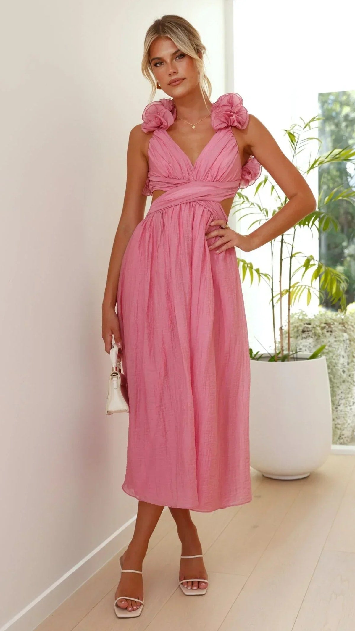 Woman wearing a midi dress with V-neck and floral shoulders.