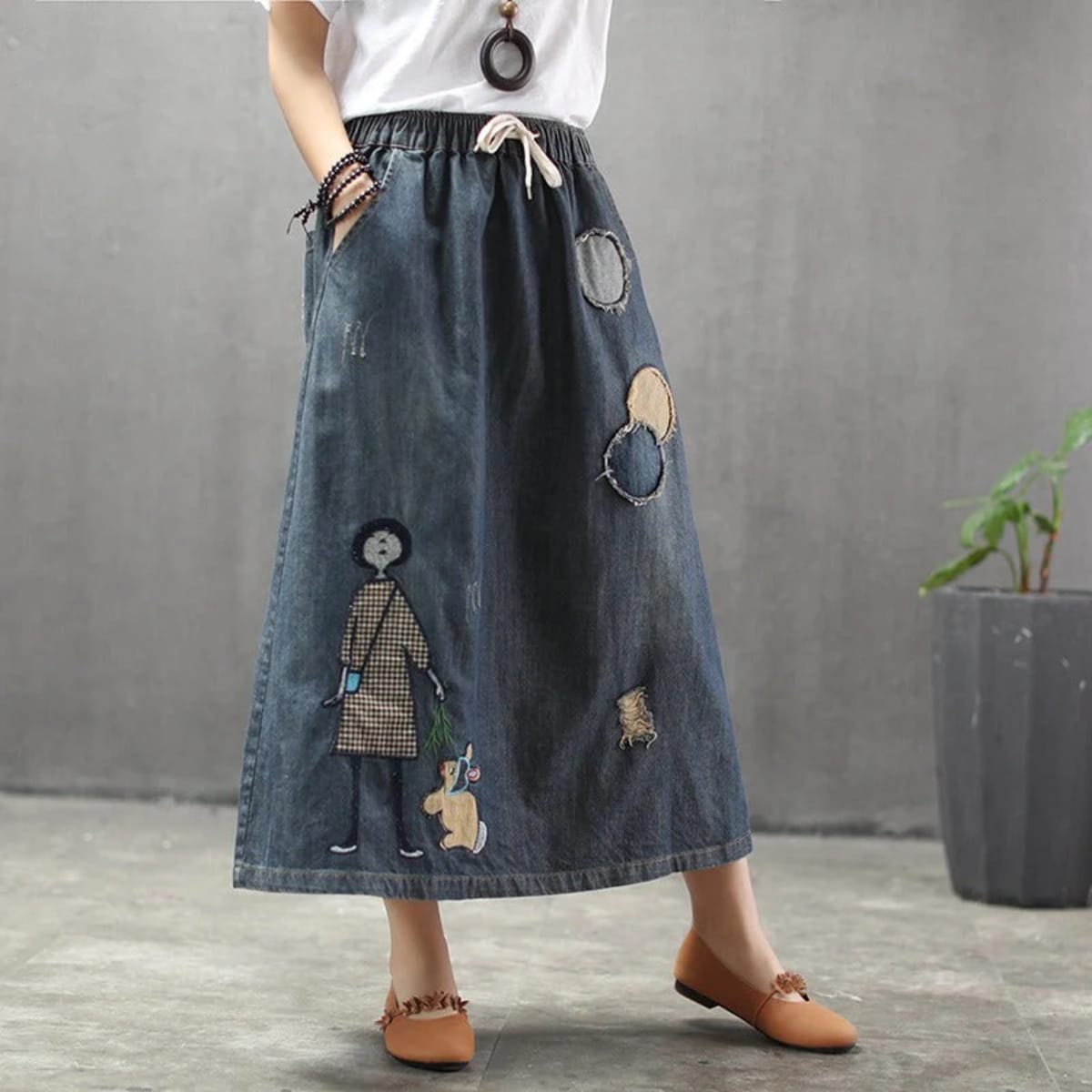 Woman wearing a denim maxi skirt with embroidery and patches