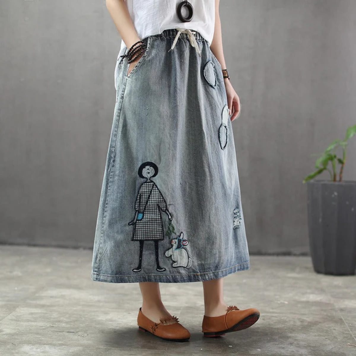 Woman wearing a denim maxi skirt with embroidery and patches