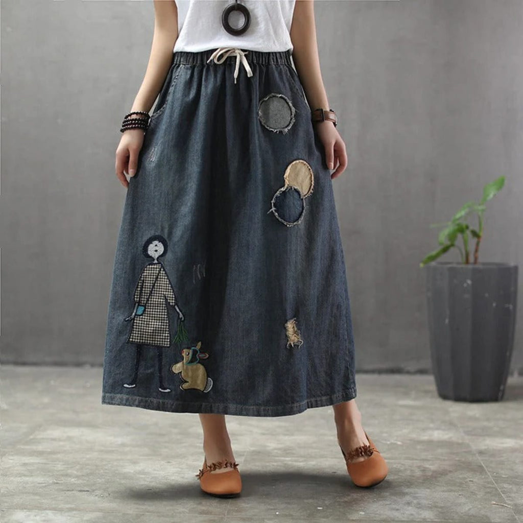 Woman wearing a denim maxi skirt with embroidery and patches