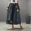 Woman wearing a denim maxi skirt with embroidery and patches