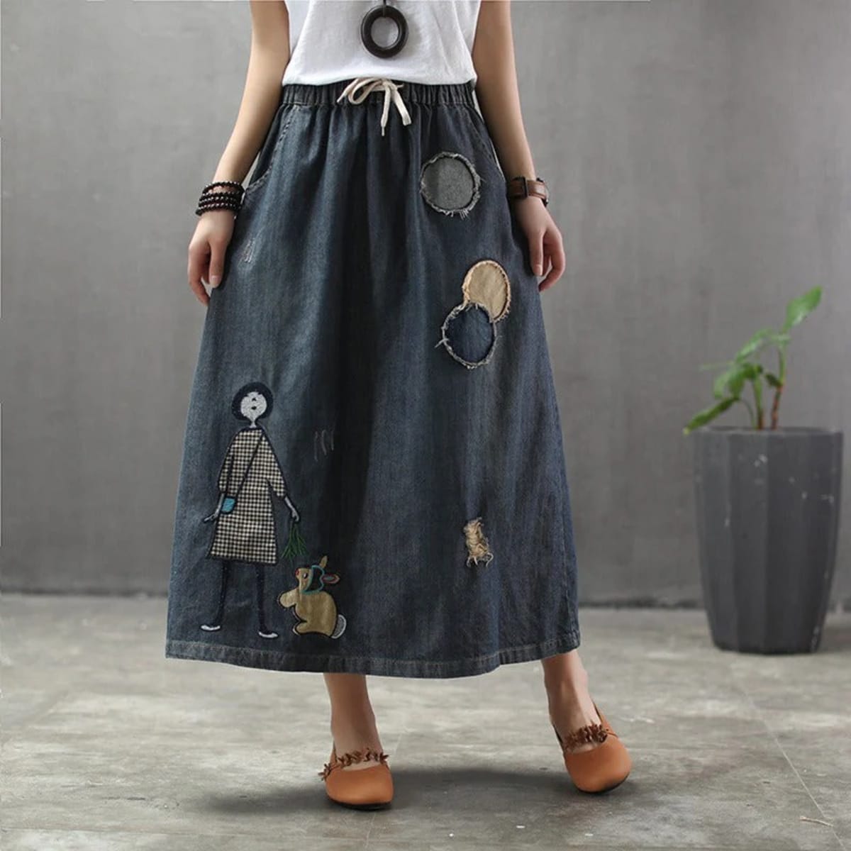 Woman wearing a denim maxi skirt with embroidery and patches