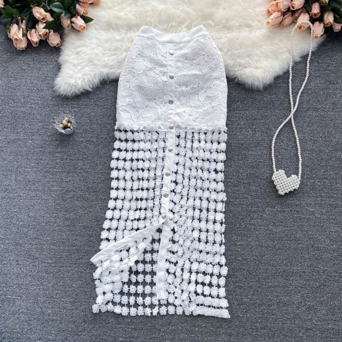 Sleeveless white lace midi dress with embellished skirt and button-down front.