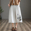 Person wears a loose-fitting midi skirt with floral embroidery.