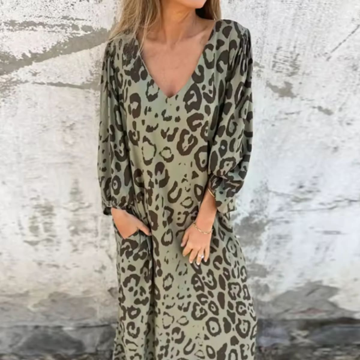 Flowing V-neck dress with long sleeves and bold patterns.