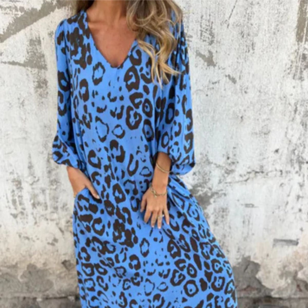 Flowing V-neck dress with long sleeves and bold patterns.