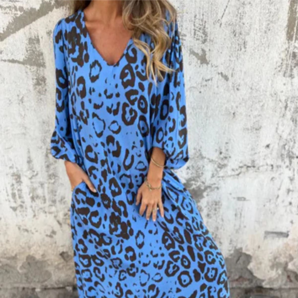 Flowing V-neck dress with long sleeves and bold patterns.