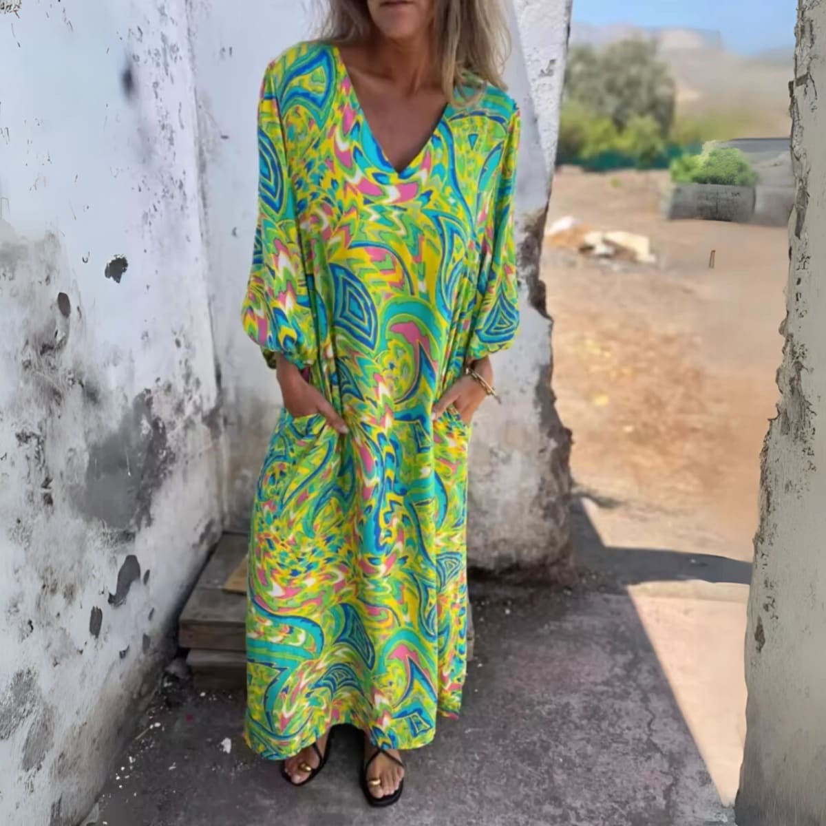 Flowing V-neck dress with long sleeves and bold patterns.