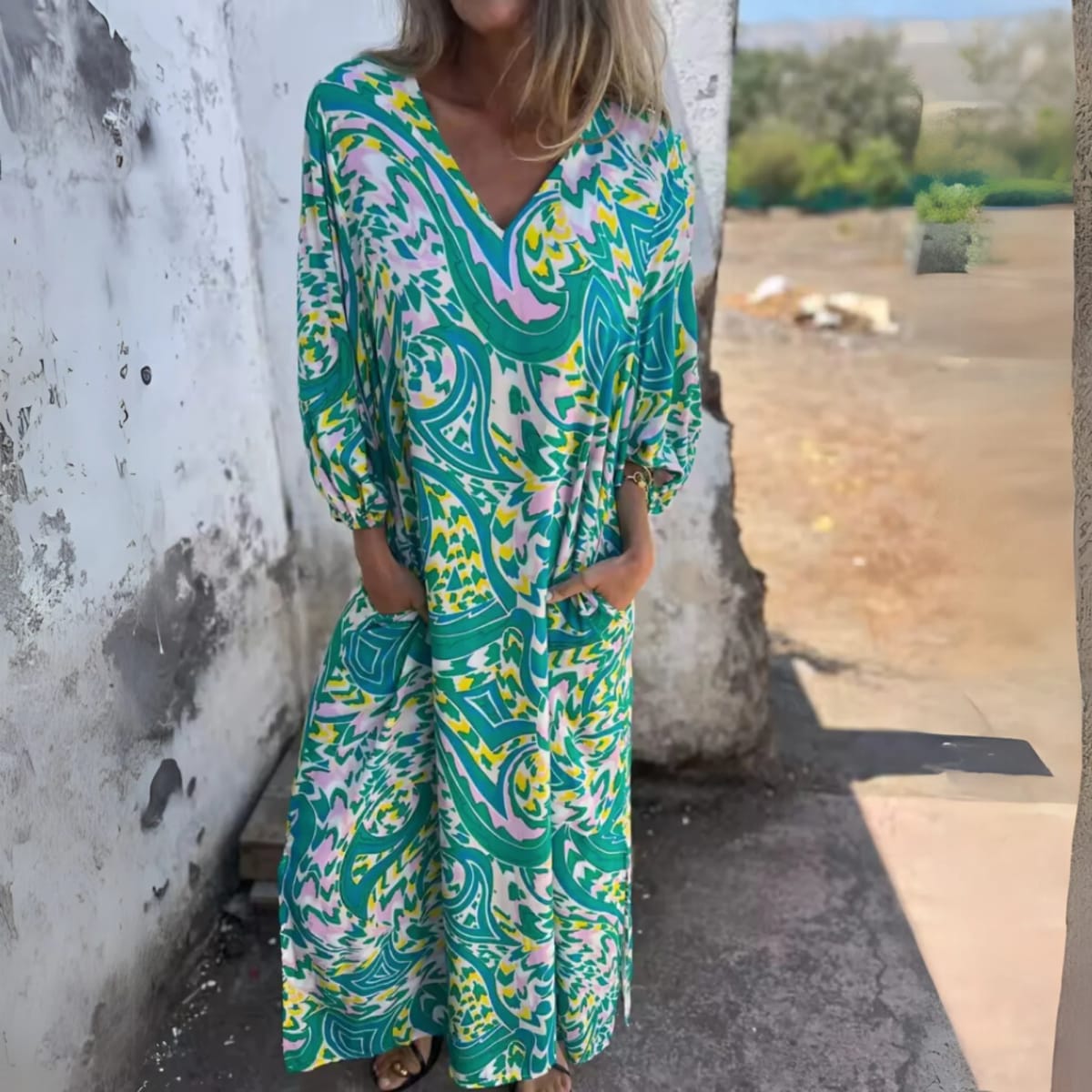 Flowing V-neck dress with long sleeves and bold patterns.