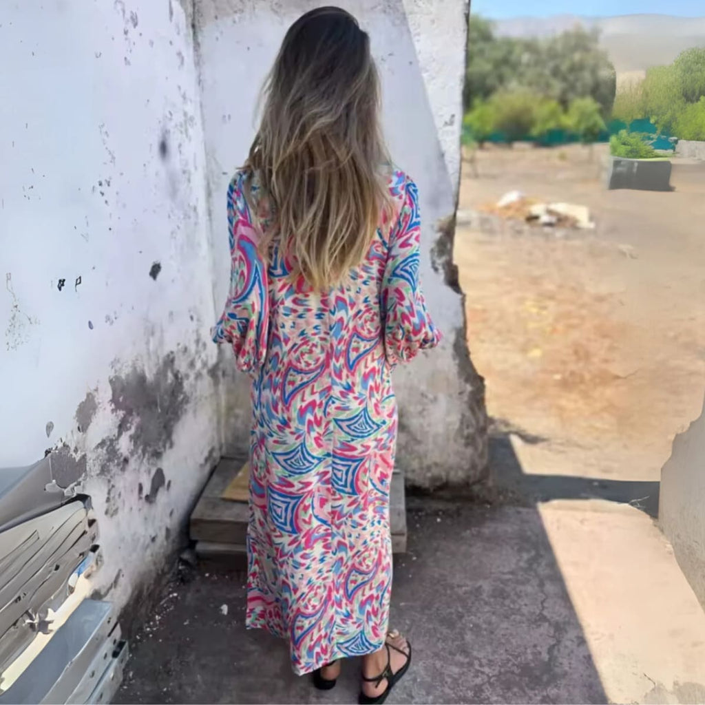 Flowing V-neck dress with long sleeves and bold patterns.