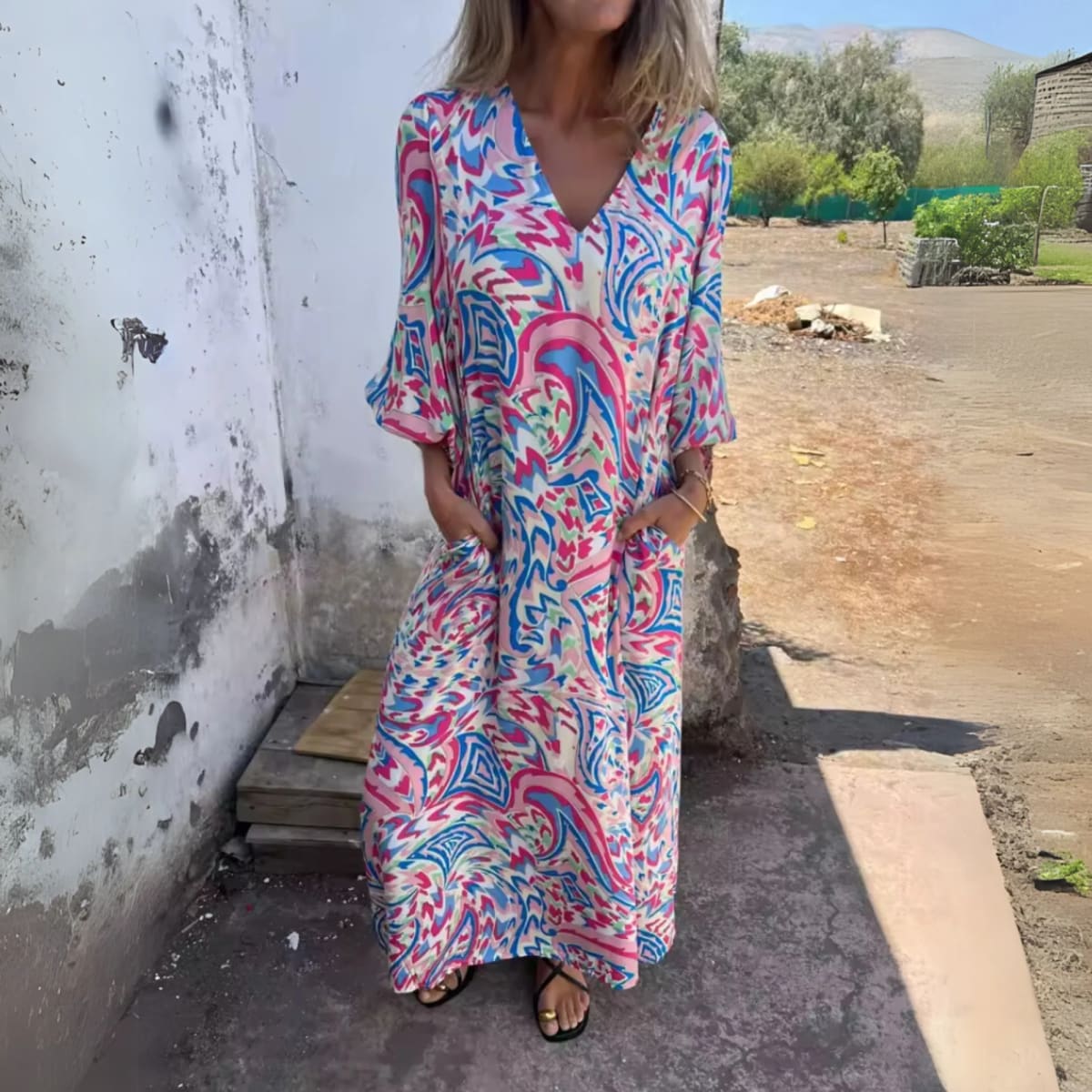Flowing V-neck dress with long sleeves and bold patterns.