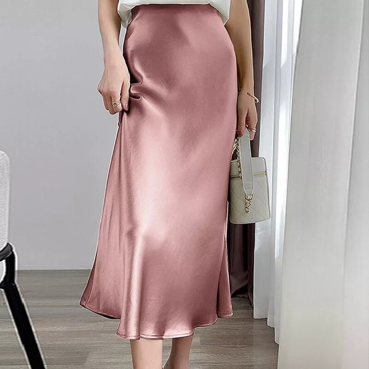 Woman wearing a high-waisted flowy midi slip skirt.