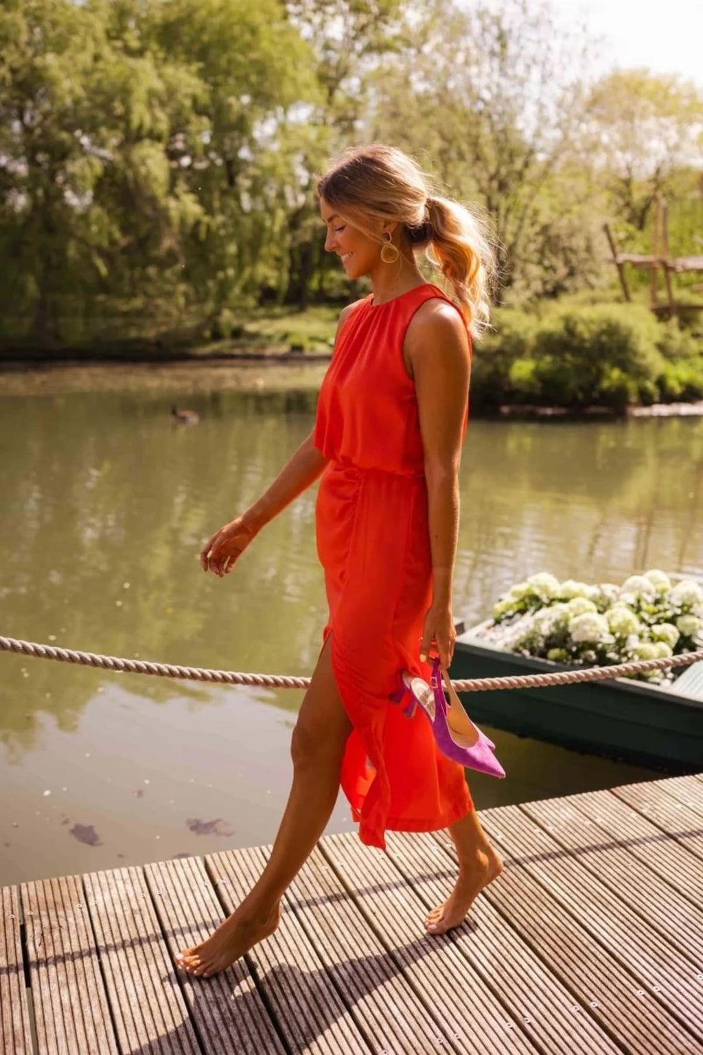 Woman in halter neck midi dress with slit on a dock.