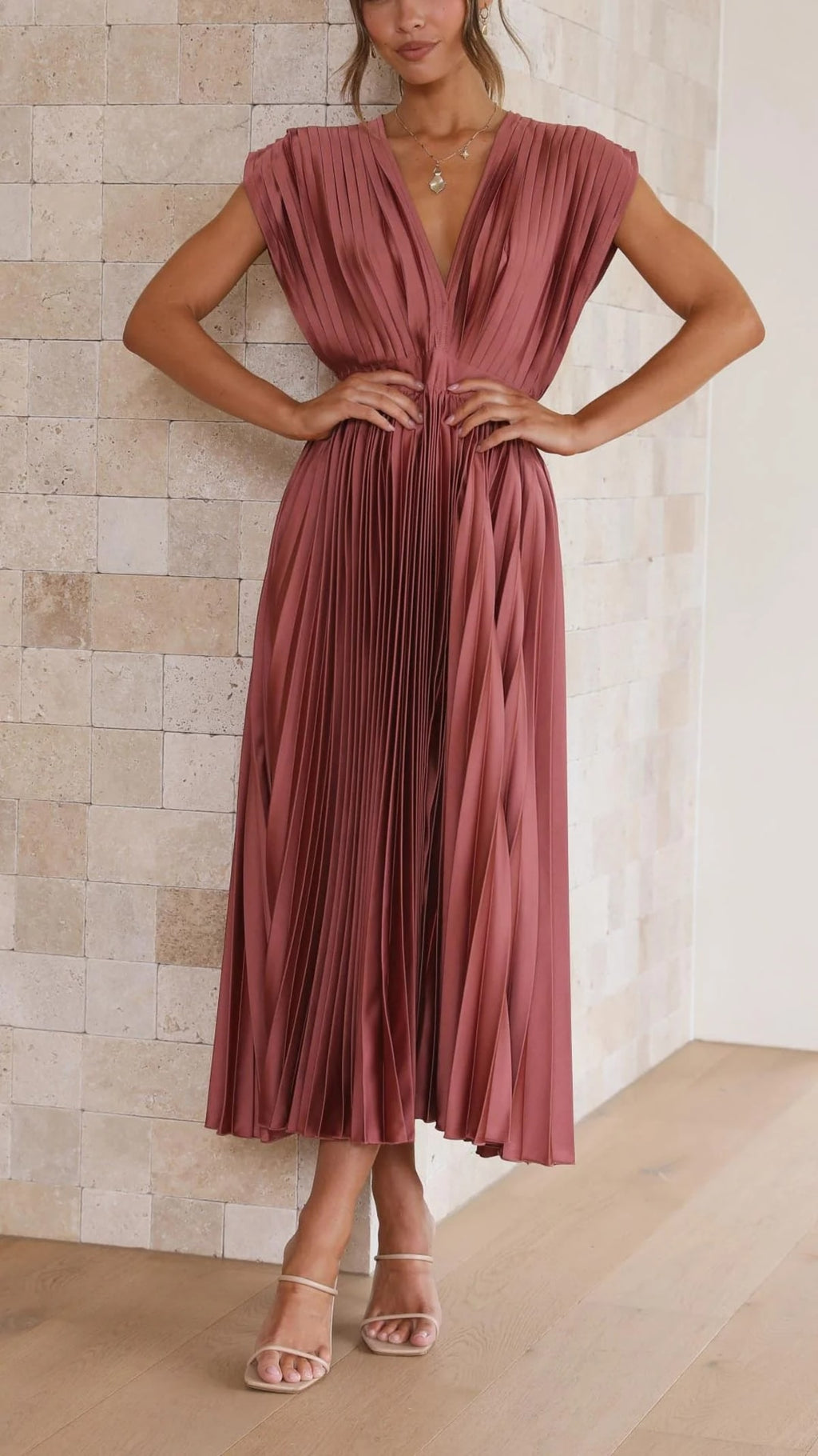 Woman wearing a pleated maxi dress with a V-neckline.
