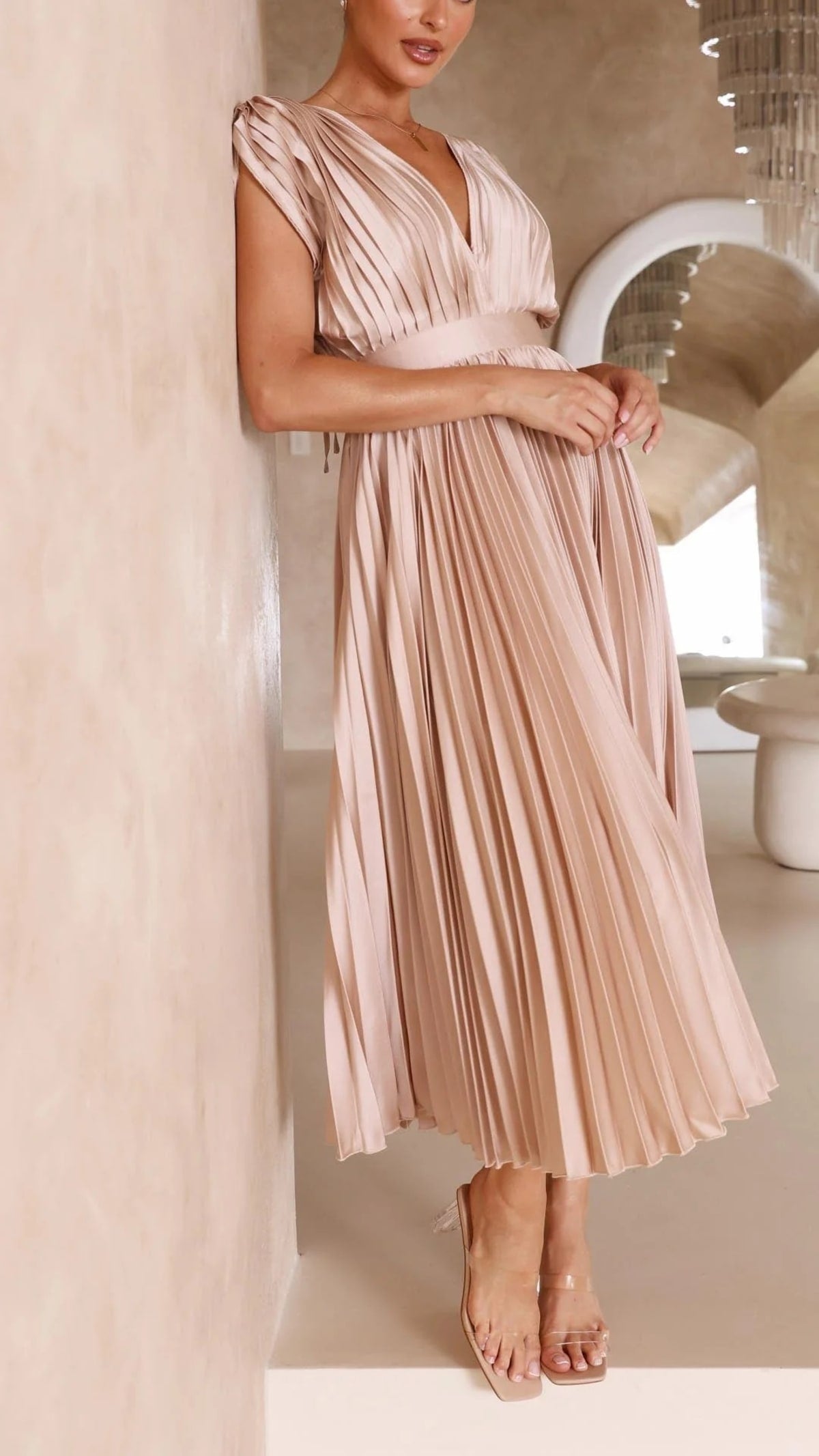Woman wearing a pleated maxi dress with a V-neckline.