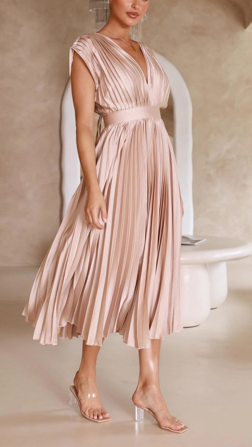 Woman wearing a pleated maxi dress with a V-neckline.