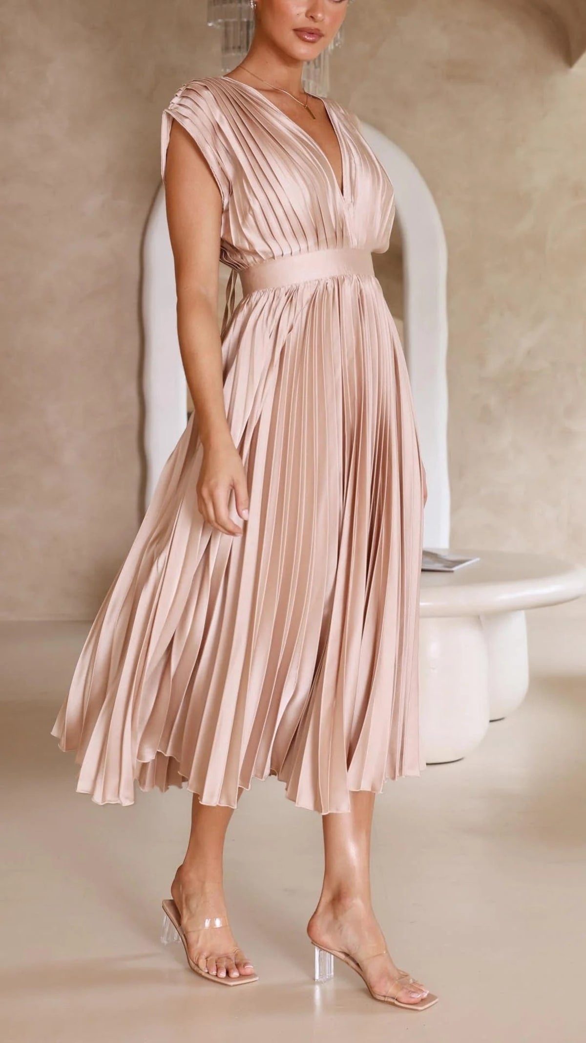 Woman wearing a pleated maxi dress with a V-neckline.