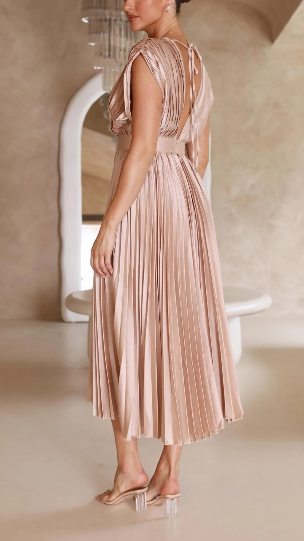 Woman wearing a pleated maxi dress with a V-neckline.