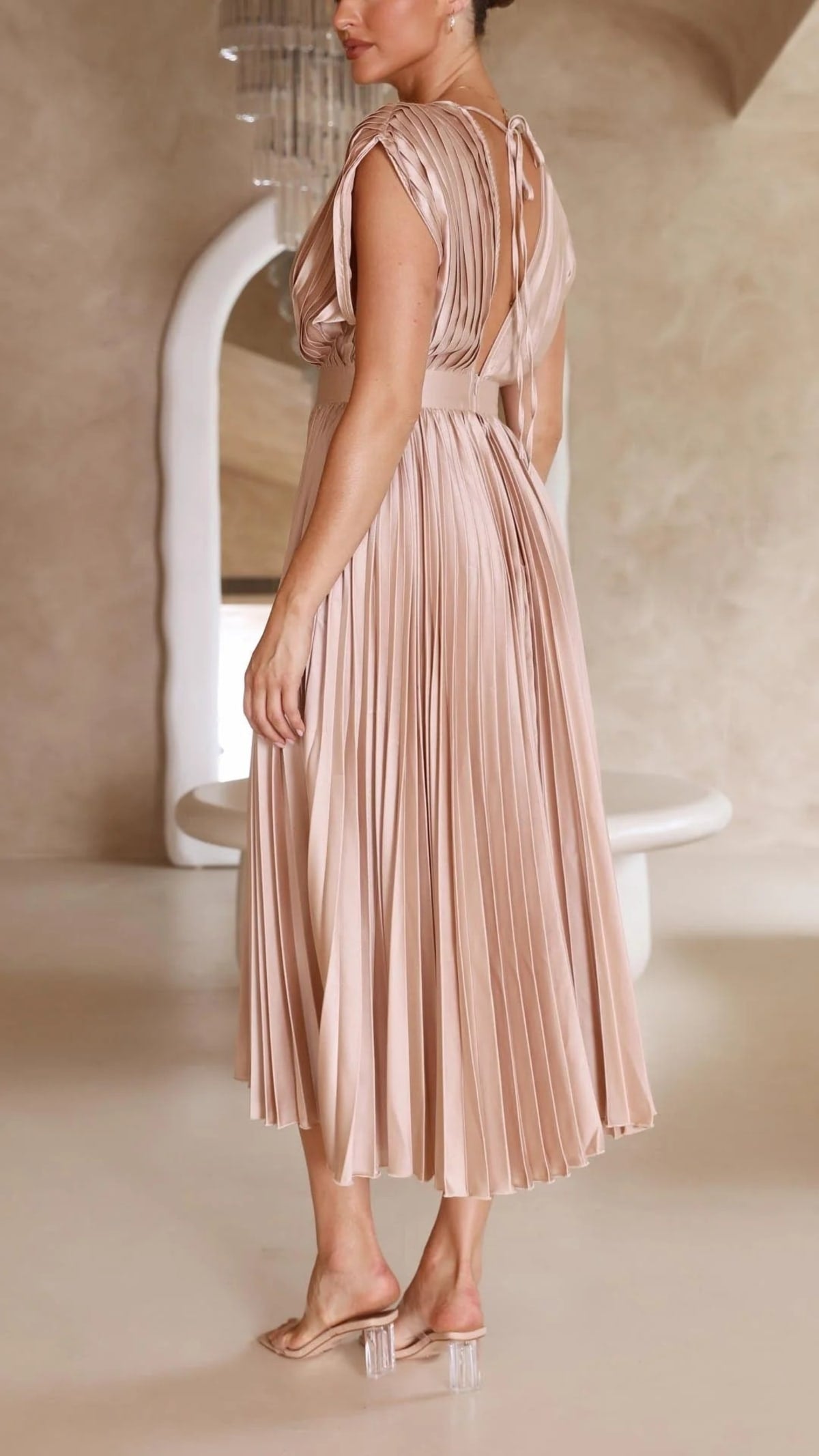 Woman wearing a pleated maxi dress with a V-neckline.