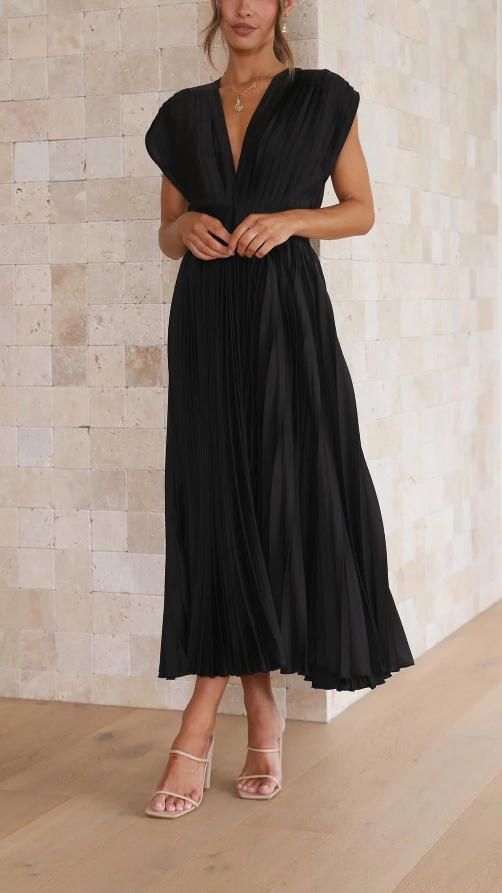 Woman wearing a pleated maxi dress with a V-neckline.