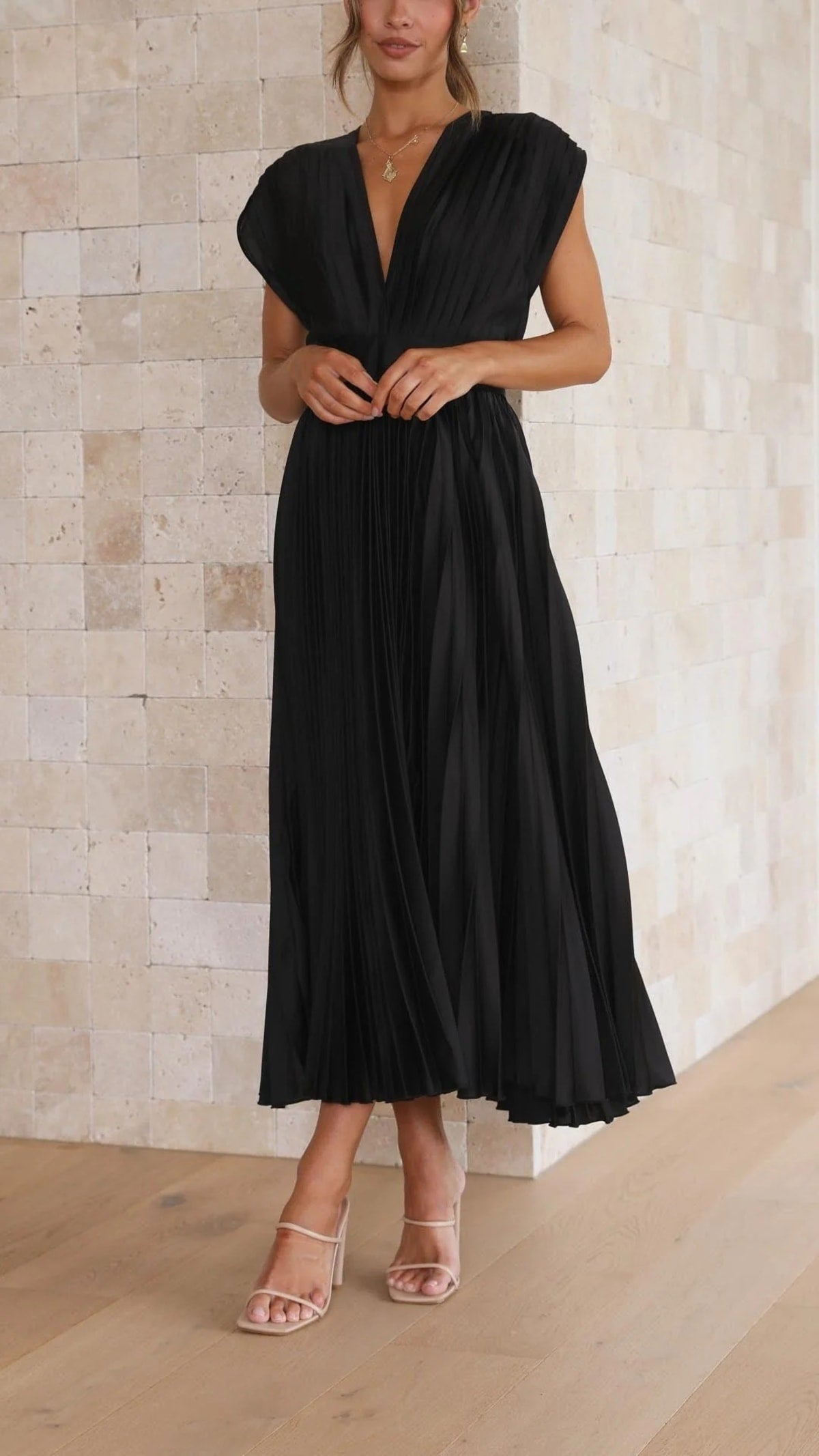 Woman wearing a pleated maxi dress with a V-neckline.