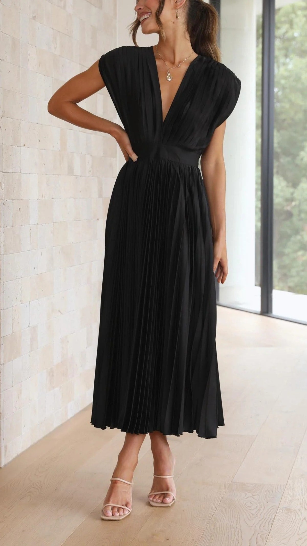 Woman wearing a pleated maxi dress with a V-neckline.