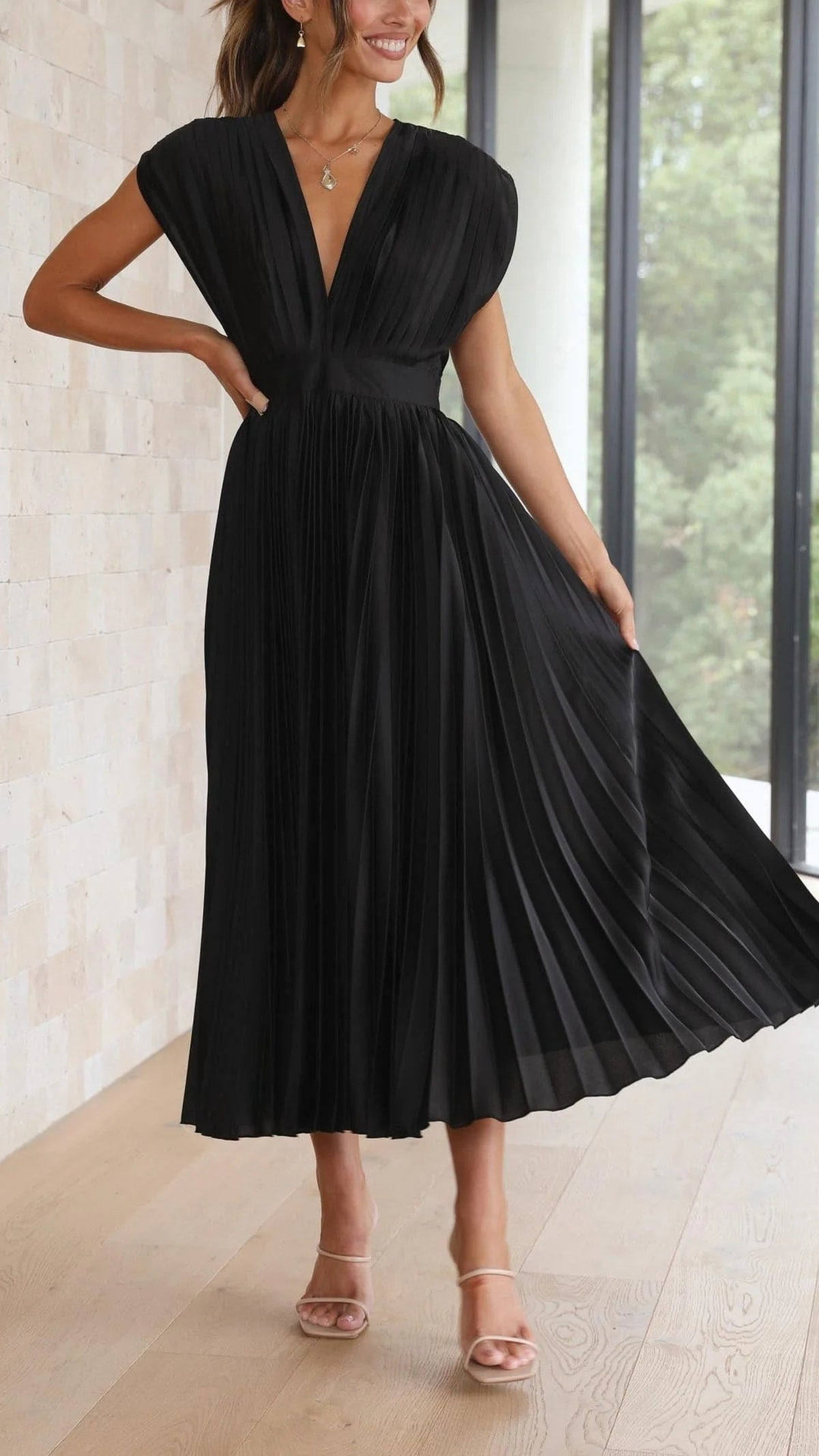 Woman wearing a pleated maxi dress with a V-neckline.