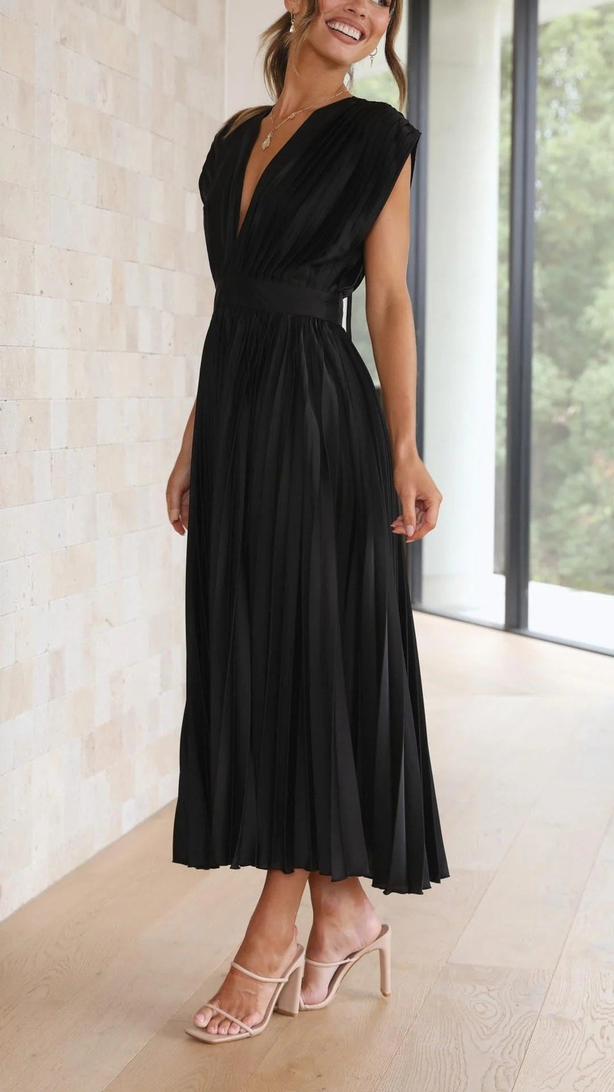 Woman wearing a pleated maxi dress with a V-neckline.