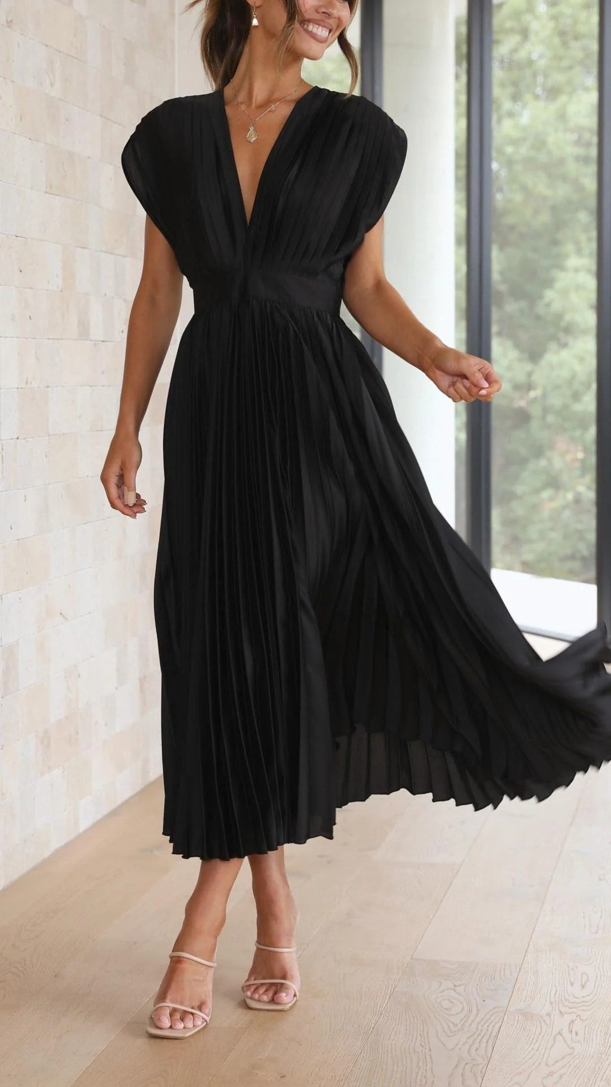 Woman wearing a pleated maxi dress with a V-neckline.