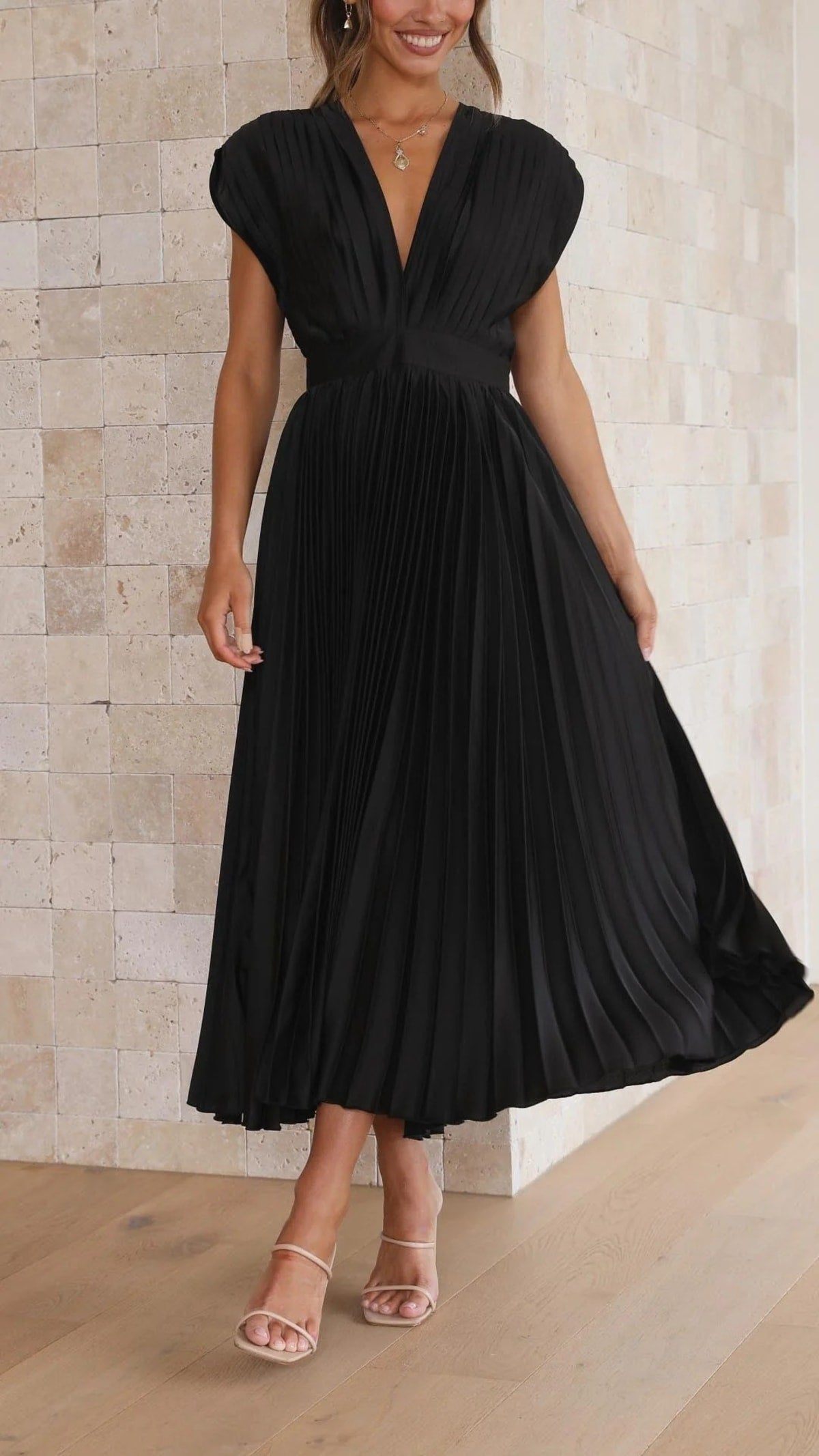 Woman wearing a pleated maxi dress with a V-neckline.