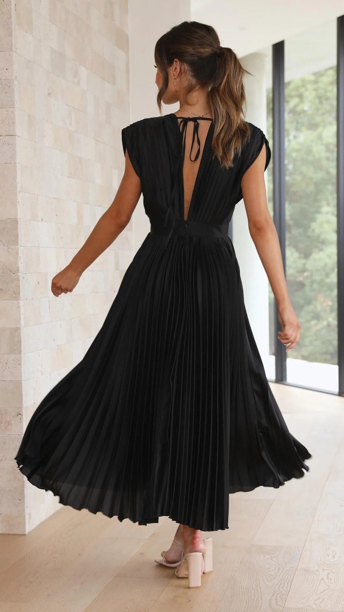 Woman wearing a pleated maxi dress with a V-neckline.