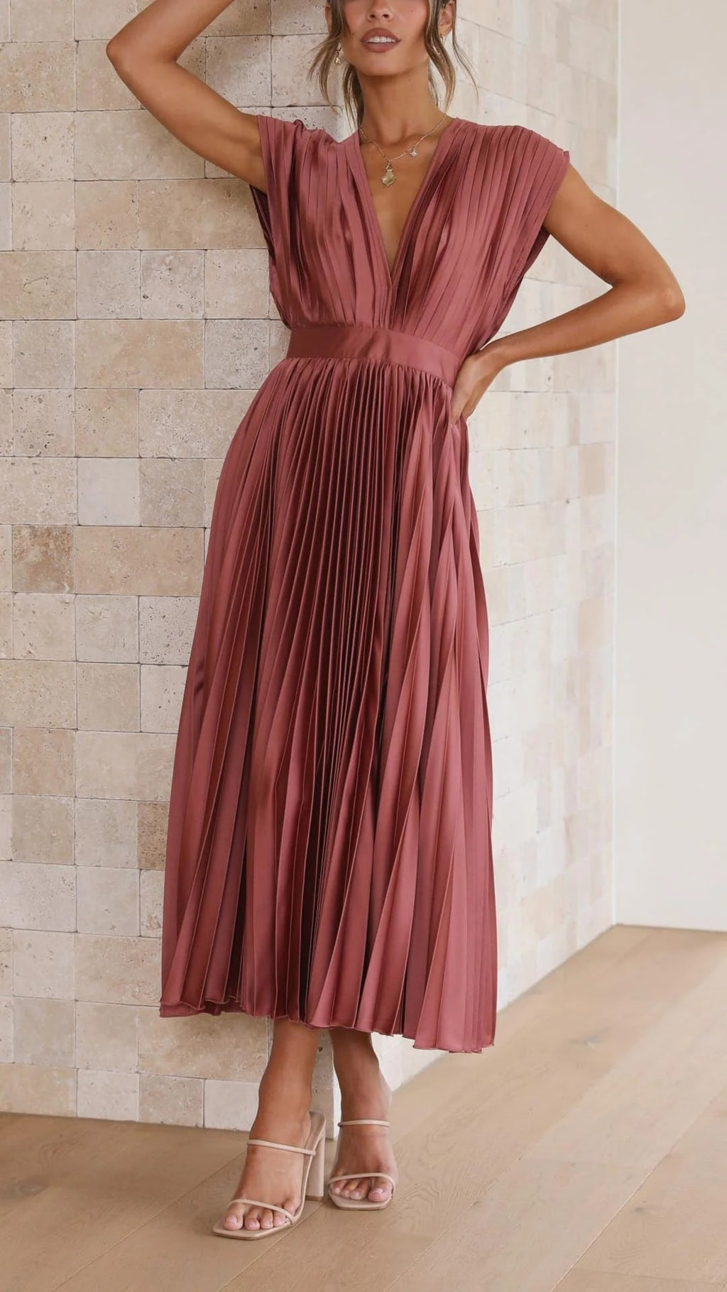 Woman wearing a pleated maxi dress with a V-neckline.