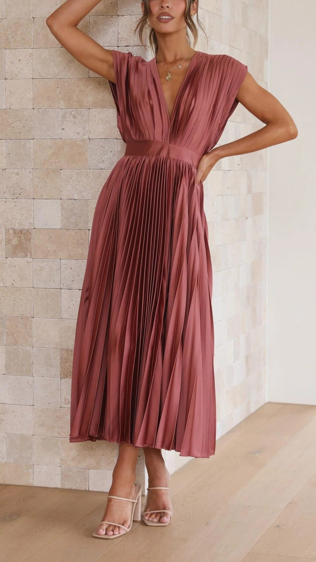 Woman wearing a pleated maxi dress with a V-neckline.