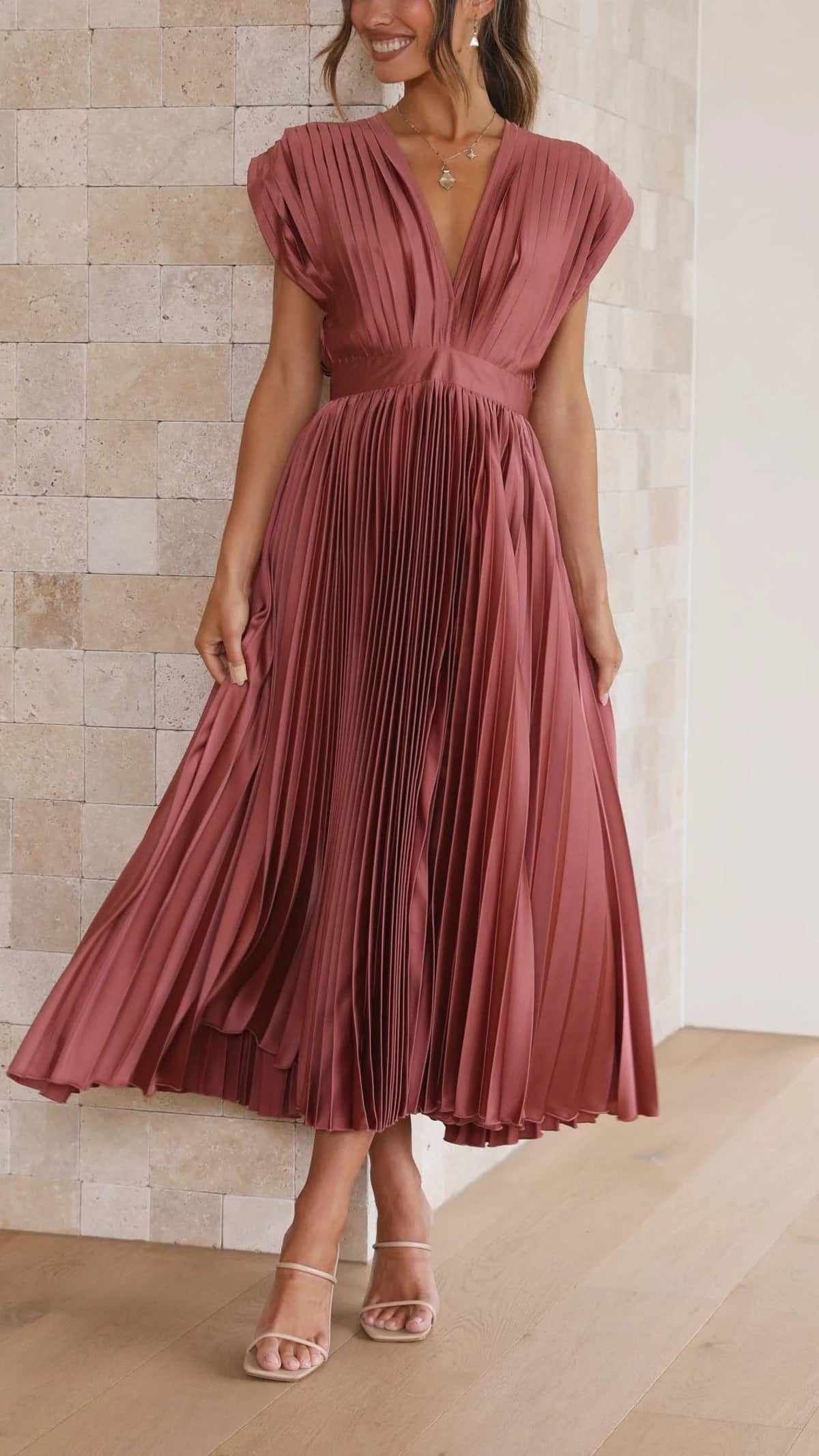 Woman wearing a pleated maxi dress with a V-neckline.