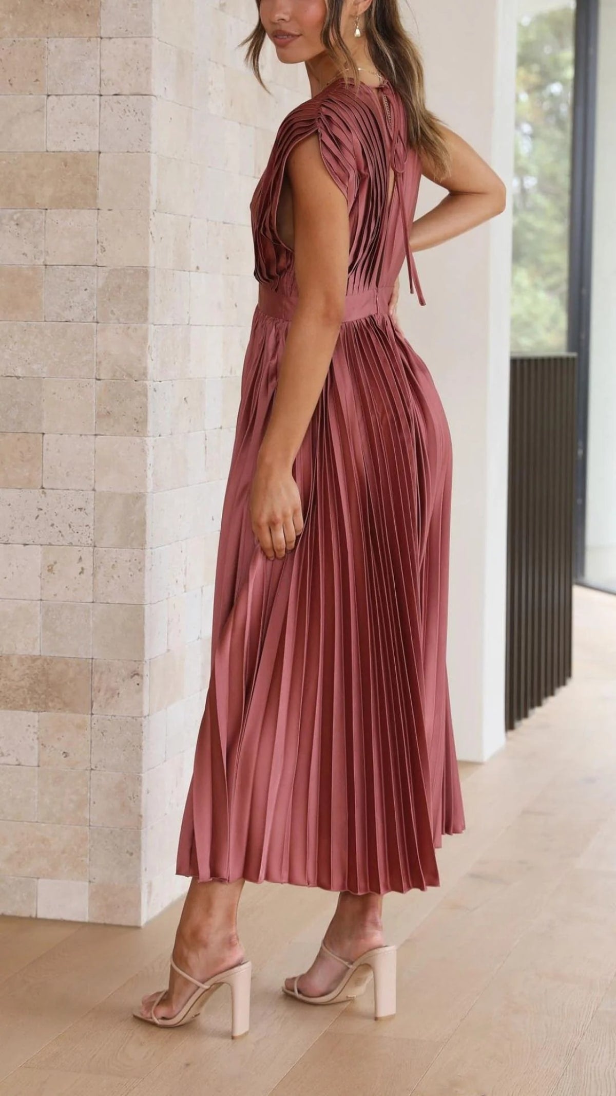 Woman wearing a pleated maxi dress with a V-neckline.