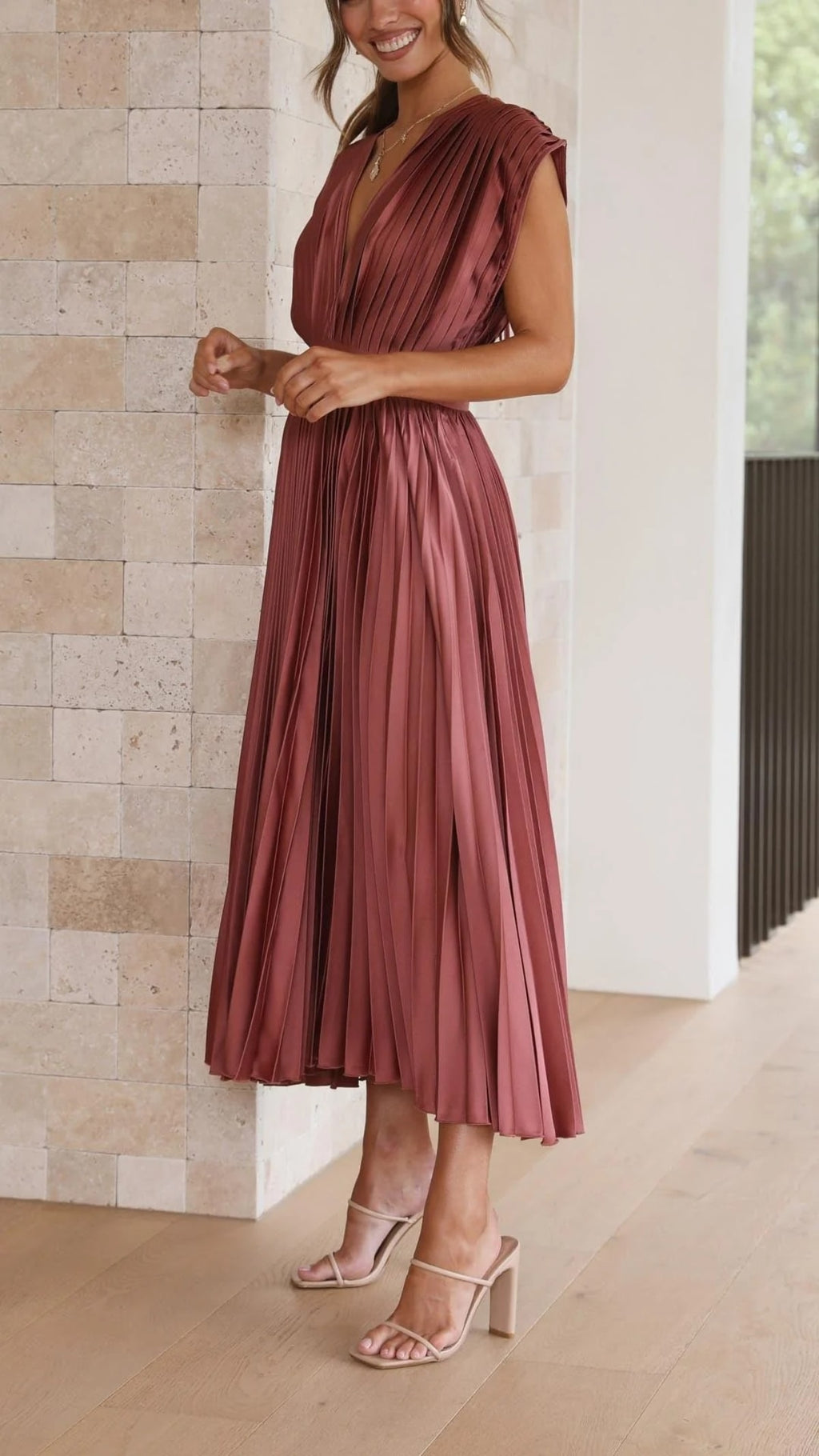 Woman wearing a pleated maxi dress with a V-neckline.