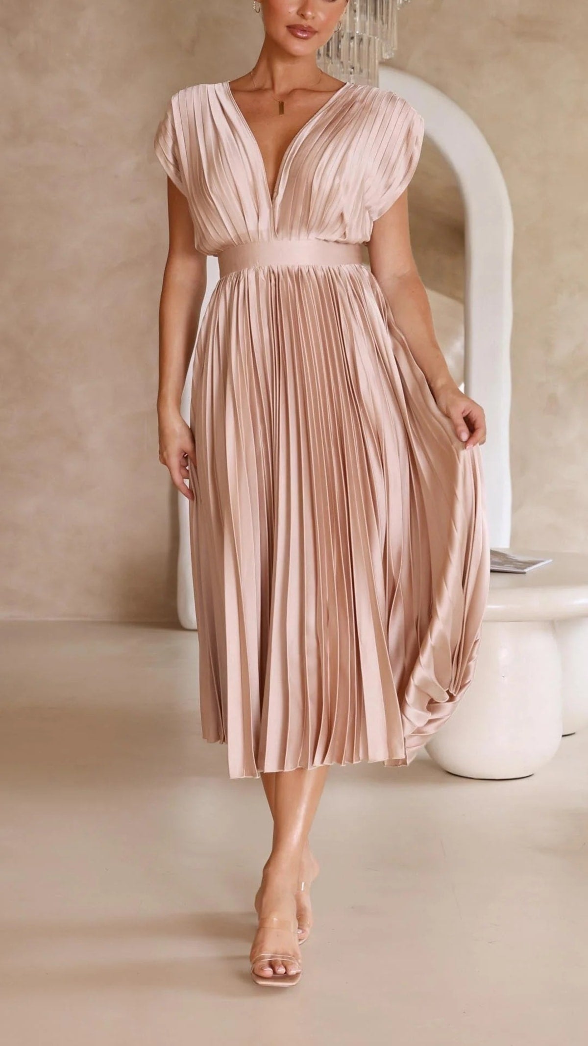Woman wearing a pleated maxi dress with a V-neckline.