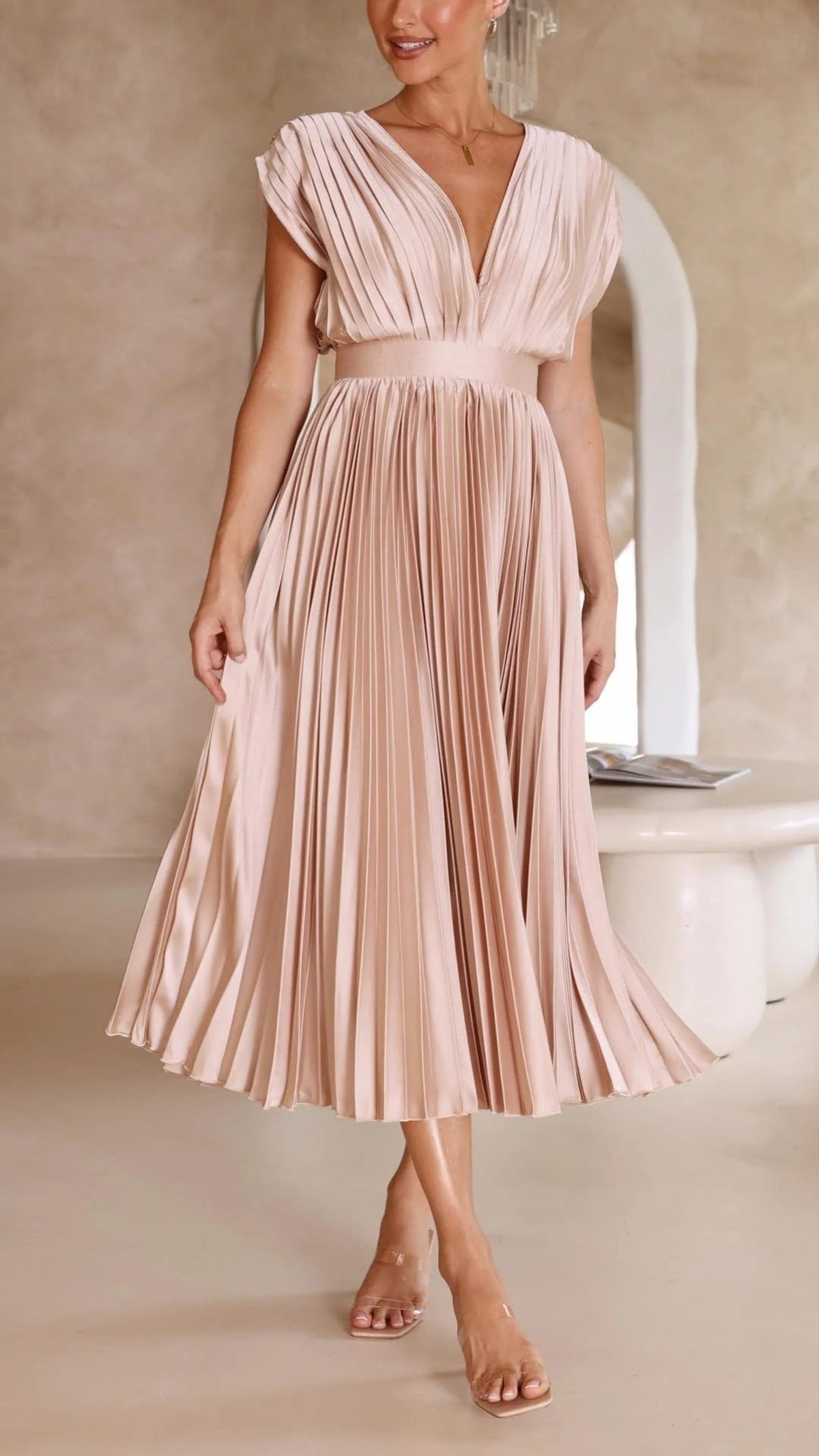Woman wearing a pleated maxi dress with a V-neckline.