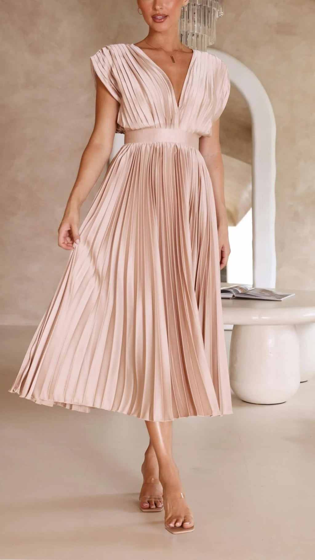 Woman wearing a pleated maxi dress with a V-neckline.