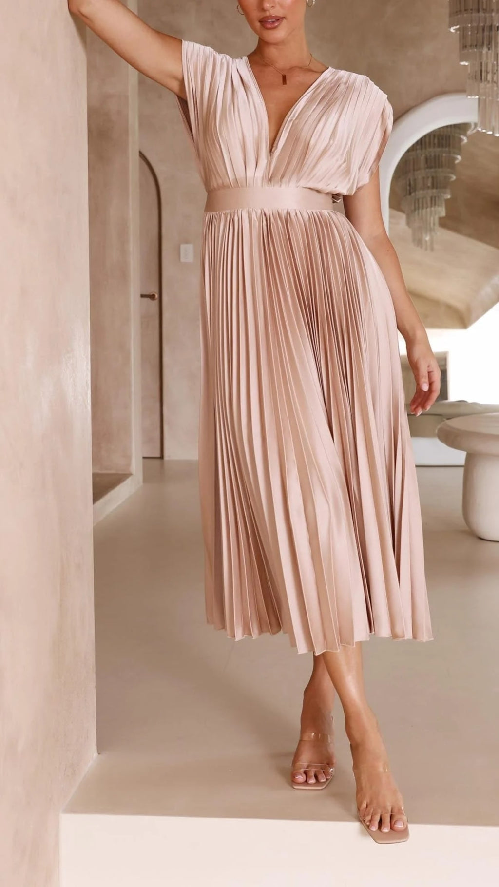 Woman wearing a pleated maxi dress with a V-neckline.